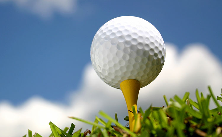 closeup of golf ball on tee from the grass